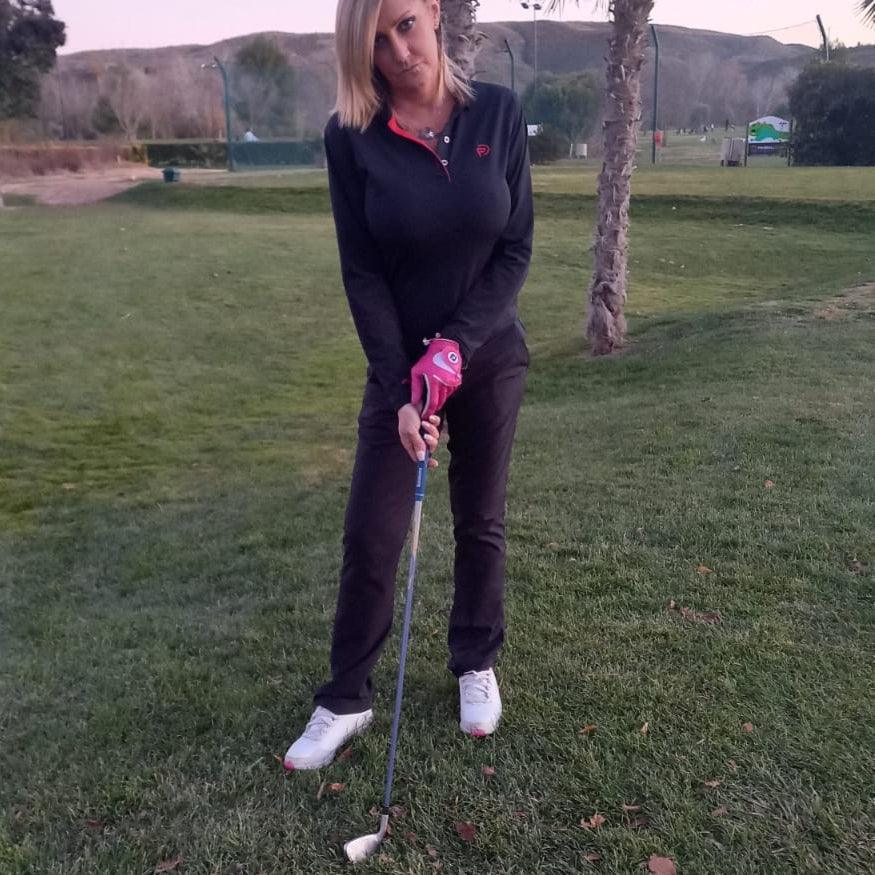 Polo de golf térmico elástico negro, detalles rojo de mujer y pantalón tecnico golf mujer negro